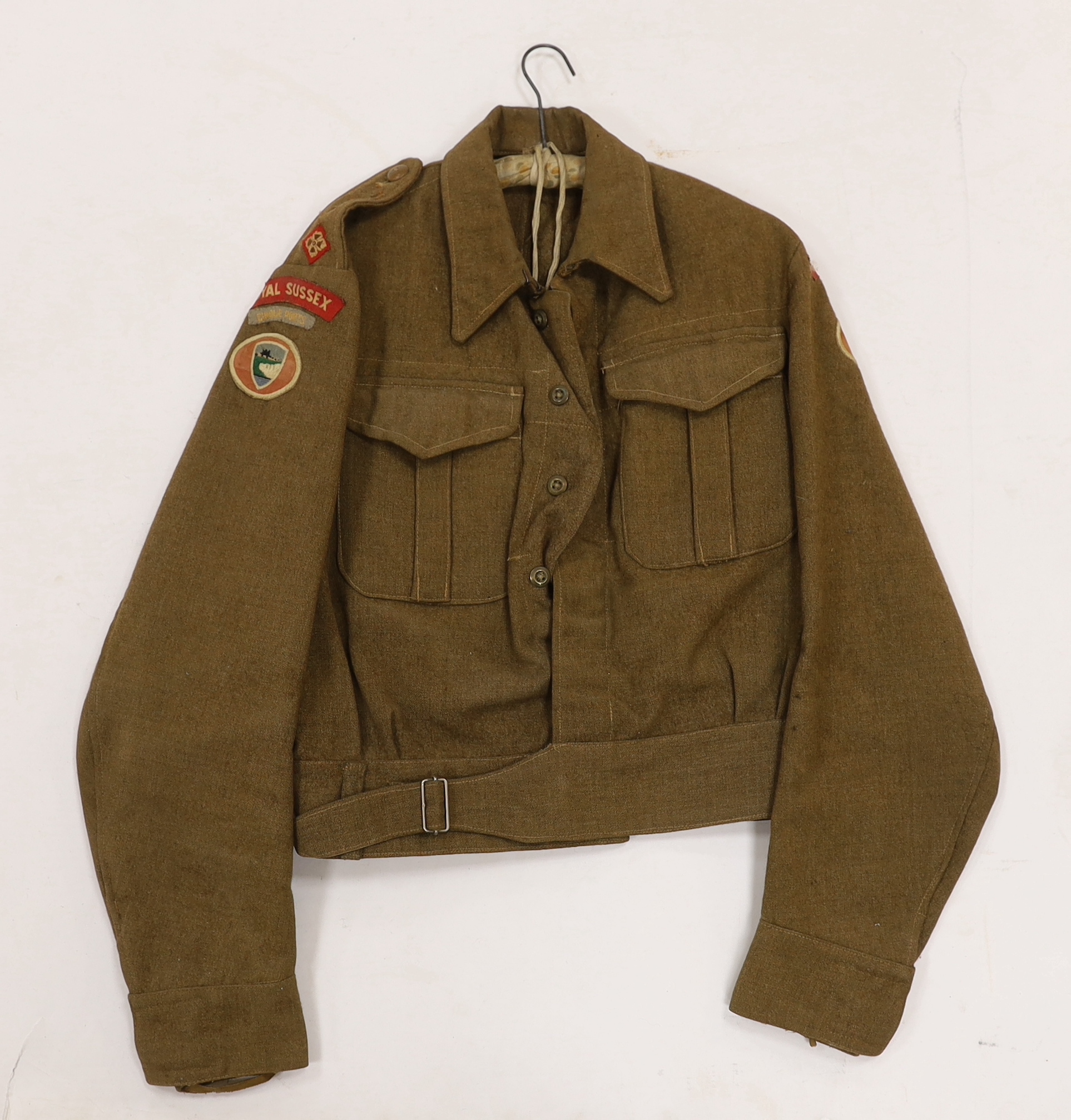 Eight British military uniform blouses/jackets, including two with Royal Sussex Regiment Cinque Ports shoulder insignia, a Queen’s A.C.F. example, etc.